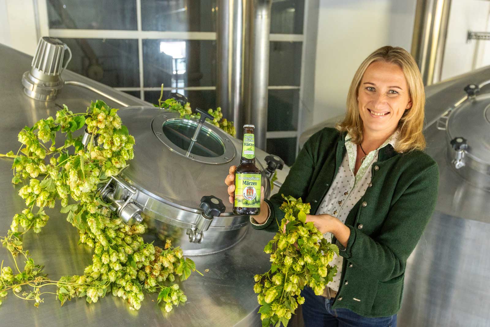 Eine Brau in der Brauerei präsentiert das Bier  Hopfenpflücker Märzen  Hopfenpflücker Märzen Hopfenpflücker Märzen